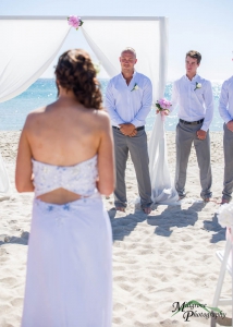Wedding photography over the bride's shoulder, looking towards the groom at Carrum Beach, Melbourne