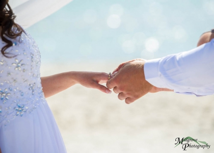 Groom placing ring on bride's finger