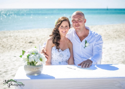 Bride and groom with their wedding certificate, at Carrum Beach