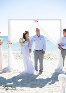 Unique bride and groom image, very smiling and happy, at the beach in Melbourne