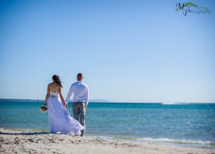 Bride Rachel and Groom Phill looking out toward the ocean, on the beach at Carrum