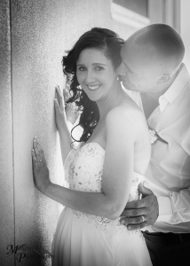 Groom whispering to bride as she's smiling