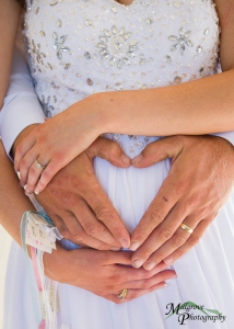 Groom makes heart shape on pregnant tummy