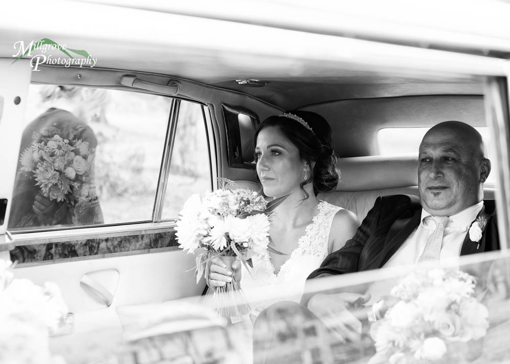 A bride in a wedding car in black and white