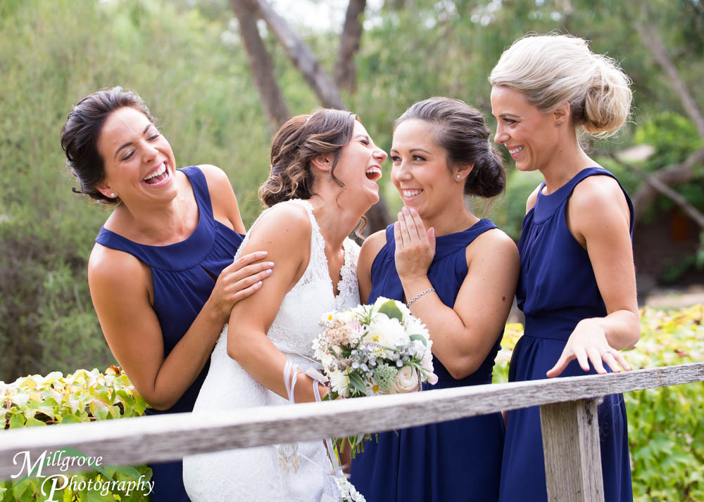 A bride laughing with her bridesmaids