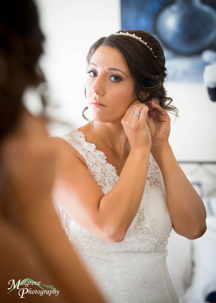 Bride putting on earrings before Inglewood Estate wedding