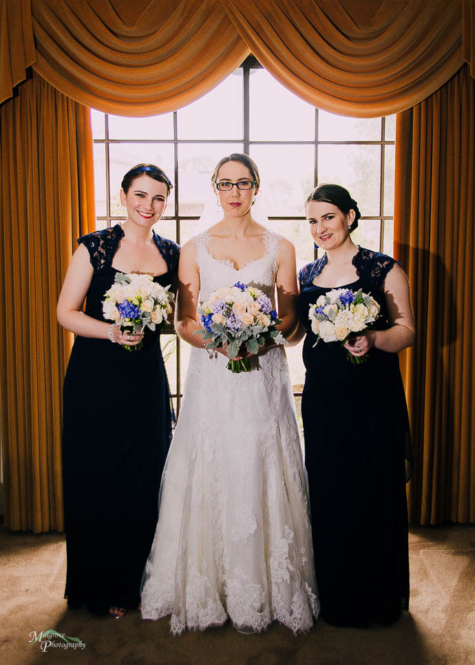 Bride and her bridesmaids in front of a window