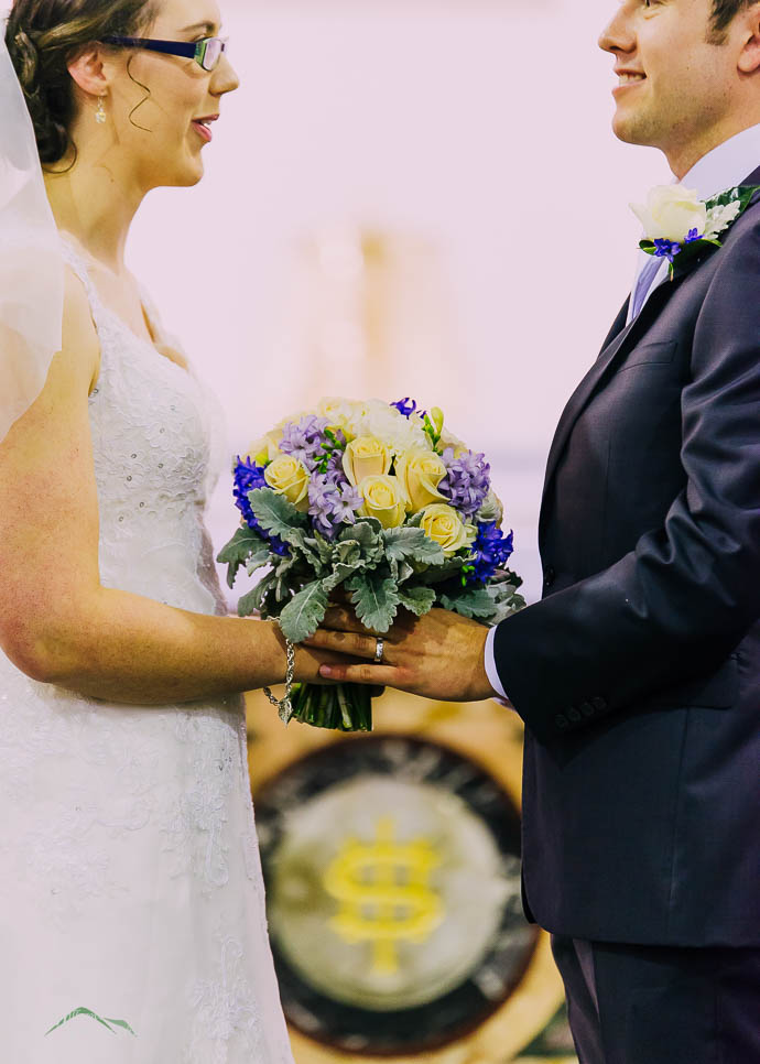 Bride and groom holding flowers in a church