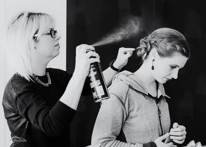 Bridesmaid getting hair sprayed