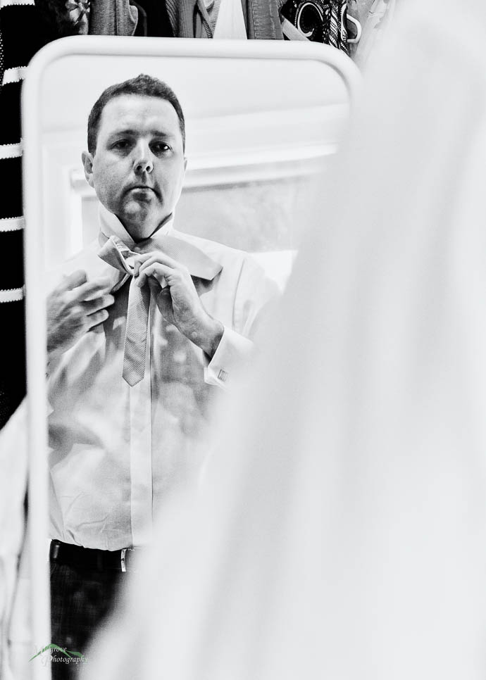 Grom doing his tie in the mirror
