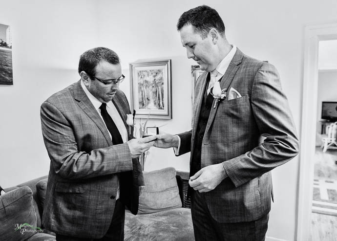 Groom giving rings to groomsman