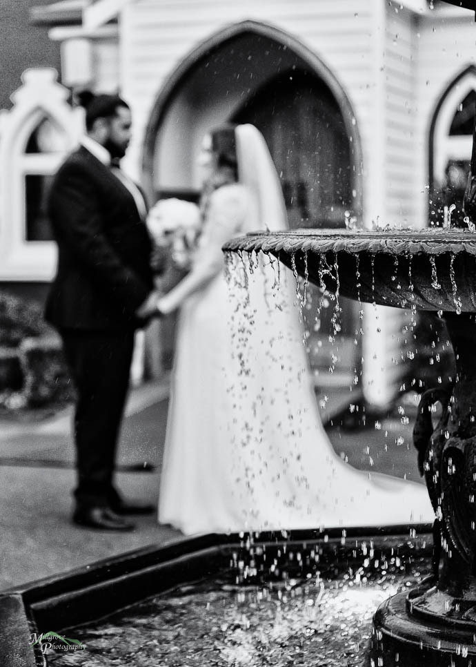 Fountain with bride and groom in background