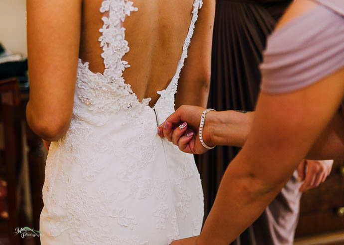 Zipping up a bride's dress