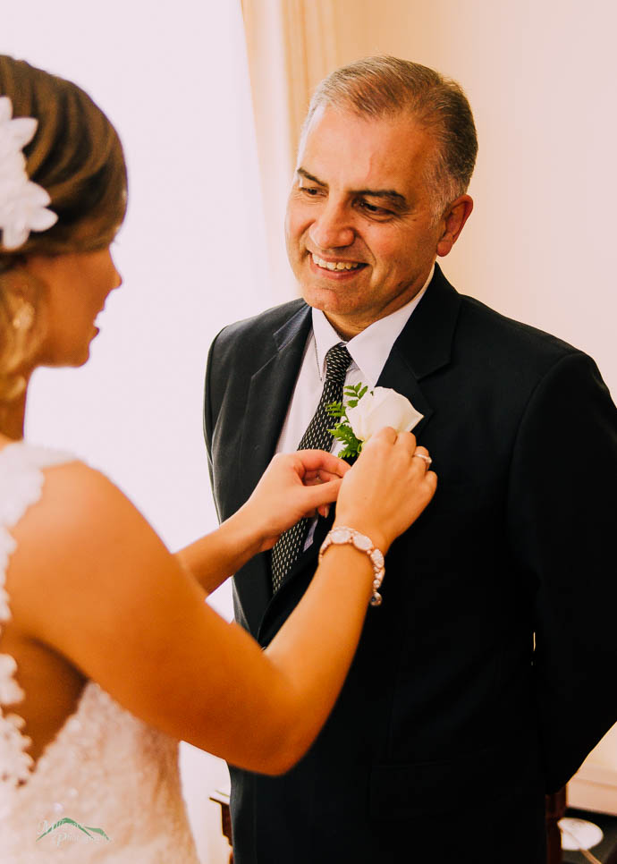 Bride pinning Dad's flower