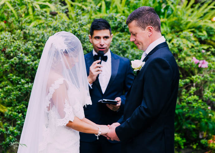 Bride and groom with celebrant in the background