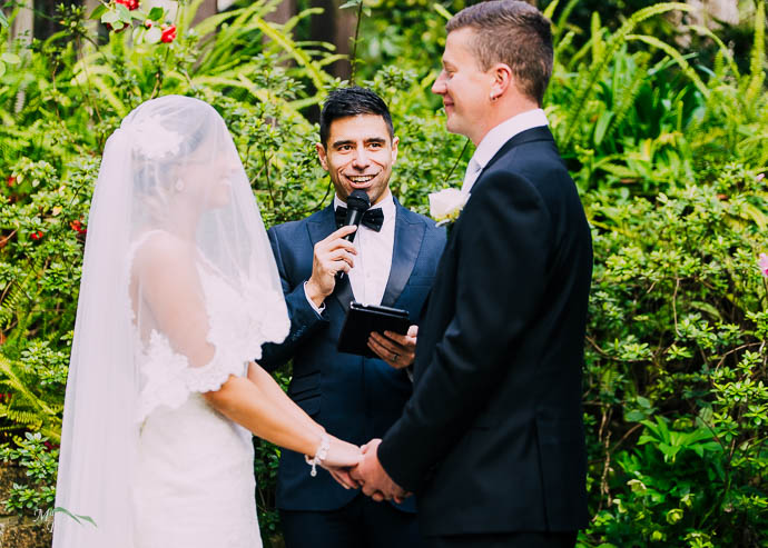 Bride and groom with celebrant in the background