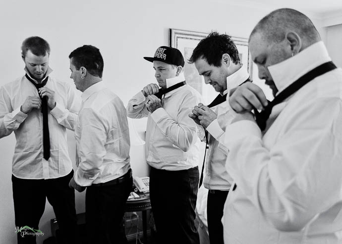 Groomsmen doing up ties, wedding preparations