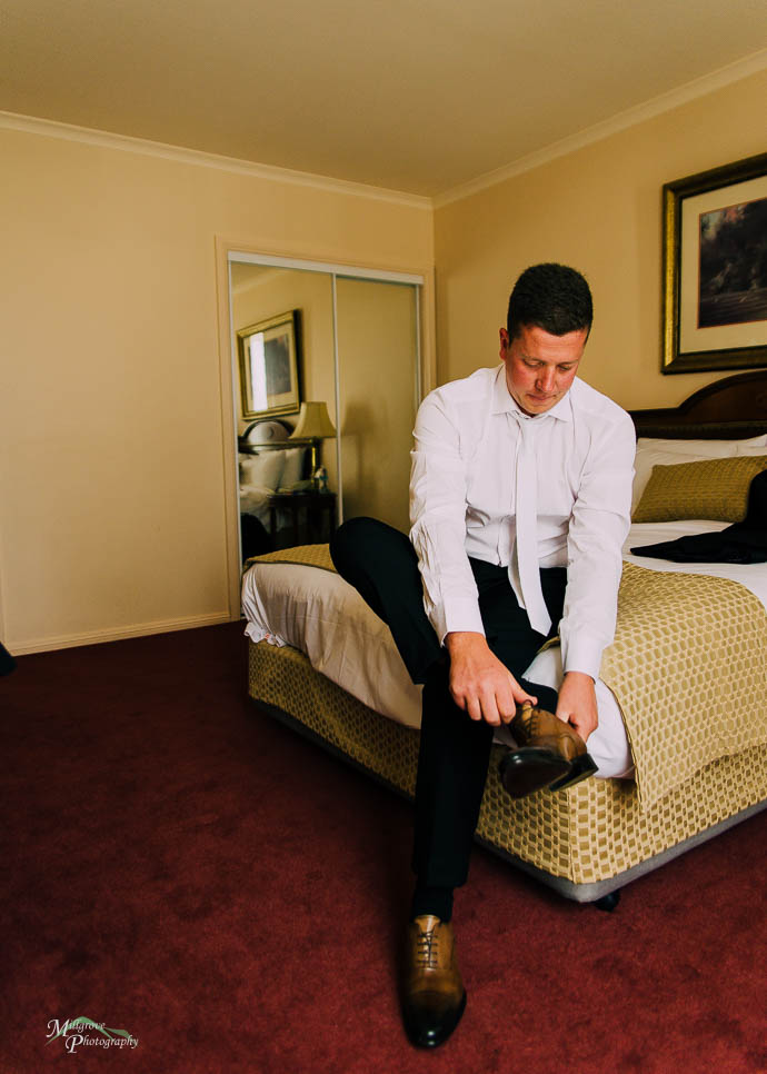 Groom putting on his shoes, wedding preparations