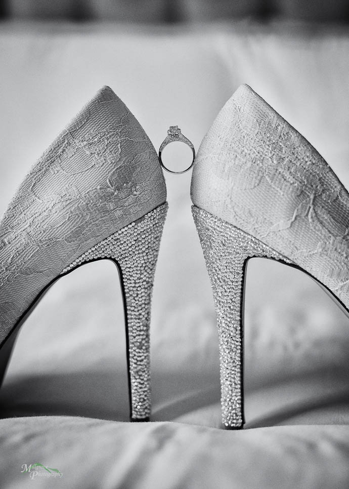 Engagement ring balanced between bride's shoes