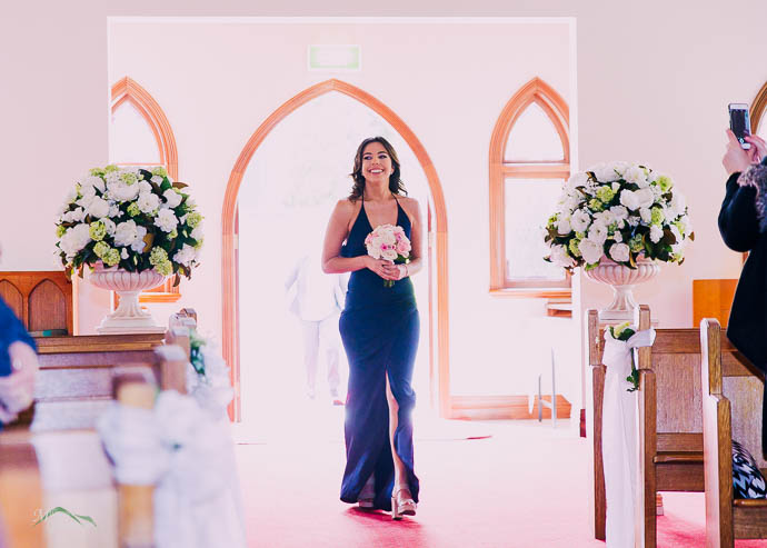 Bridesmaid walking down the aisle in the chapel at Ballara Receptions