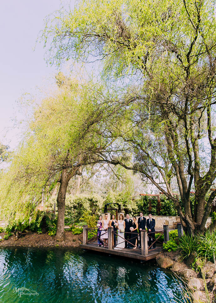 Bridal party on a pontoon with a lake in the foreground