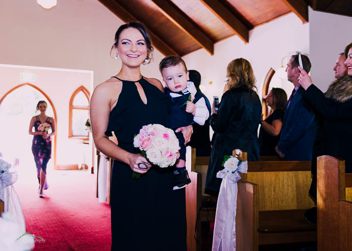 Bridesmaid walking down the aisle in the chapel at Ballara Receptions