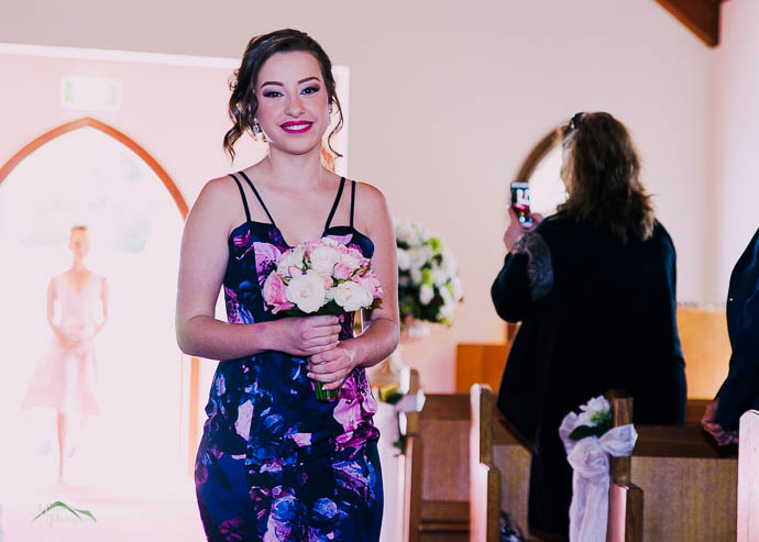 Bridesmaid walking down the aisle in the chapel at Ballara Receptions