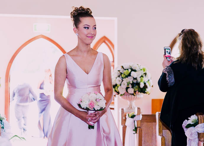 Bridesmaid walking down the aisle in the chapel at Ballara Receptions