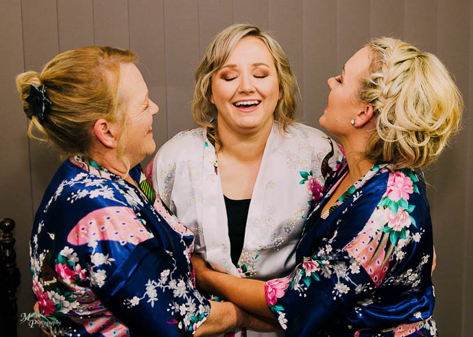 Bride, bridesmaid and laughing in robes