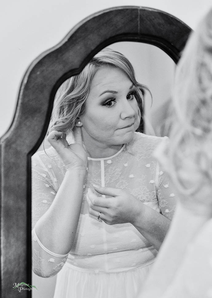 Bride in the mirror with earrings, black and white