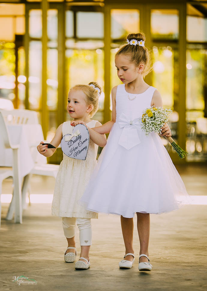 Two small flower girls walking down th aisle at Two Brookes Bar
