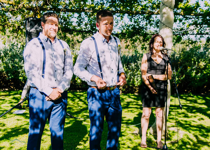 Groom and groomsmen waiting in dappled light