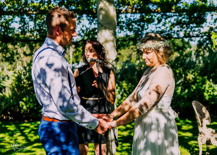 Bride and groom holding hands during Wedding ceremony at Two Bro
