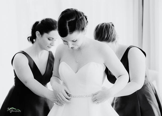 Bride putting on her earrings in the bridal suite at Lake House,