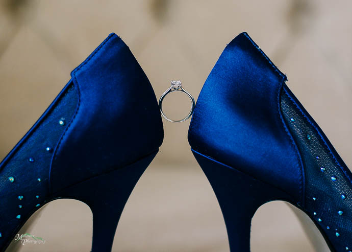 Bride’s blue shoes with ring balanced between them