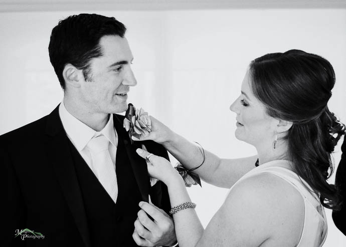 Female “Groomsman” helping Groom with his tie