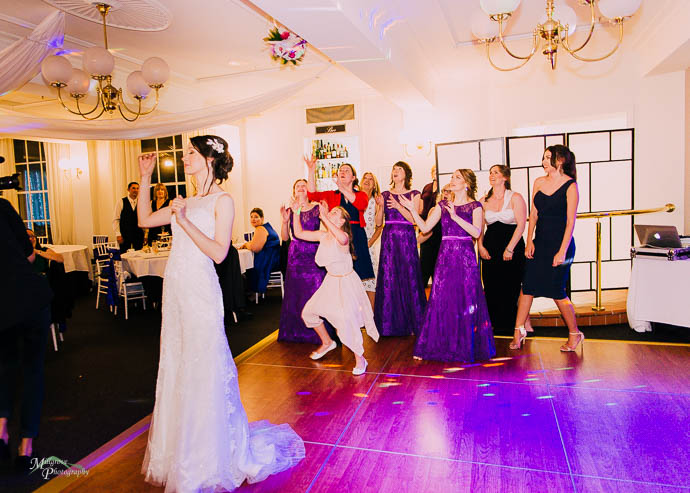 Bride throwing bouquet at wedding reception