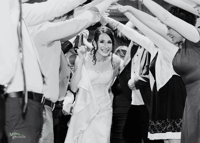 Bride walking through a farewell arch at wedding reception