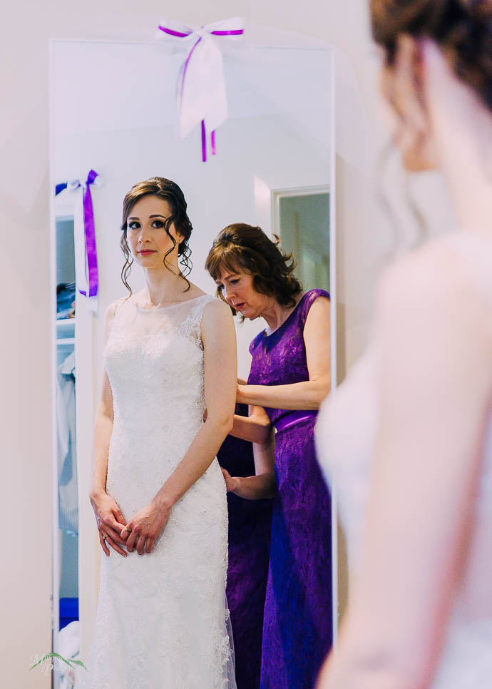 Bride getting help from her Mum in a mirror