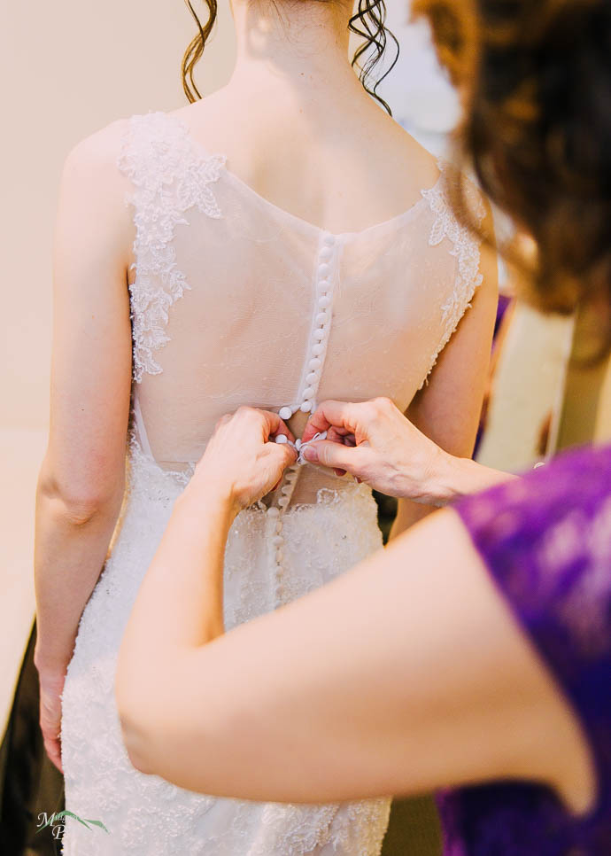 Mum helping Bride with her dress