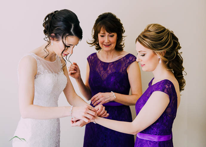 Bride helping Bridesmaid with her jewellery