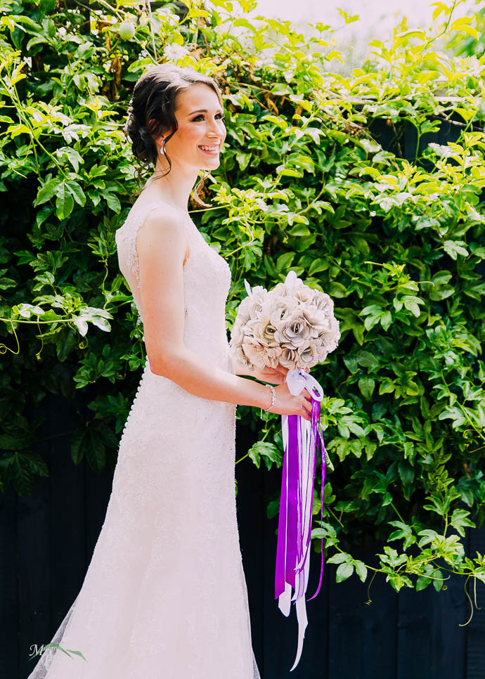 Bride with a green bush behind her