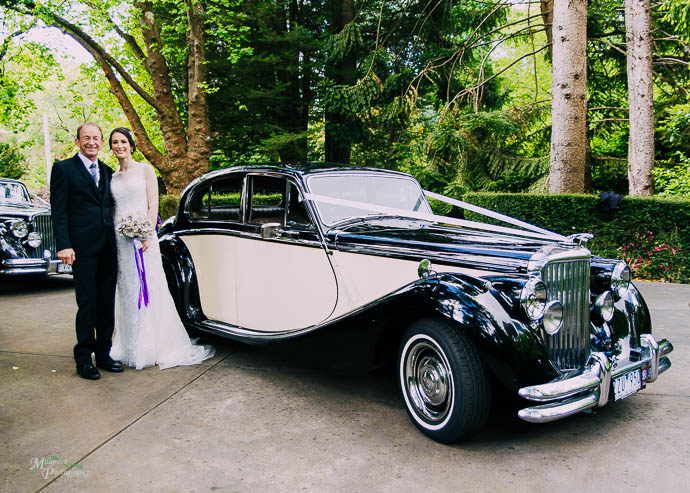Bride and father standing next to bridal car