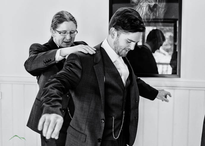 Groomsmen helping Groom with his jacket