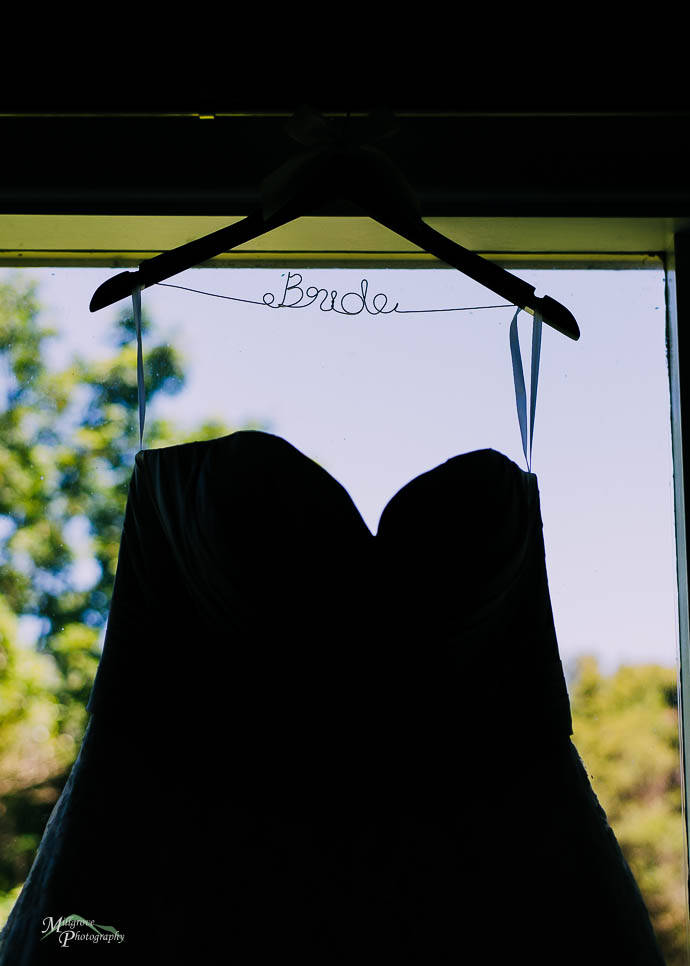Bride’s dress hanging with a hanger that says “Bride”