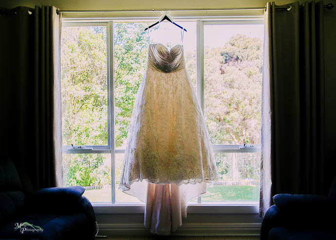 Bride’s beautiful dress hanging in the window
