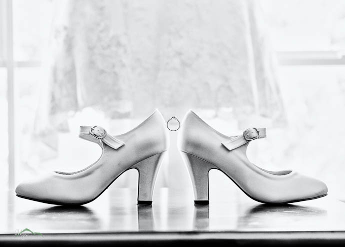 Bride’s shoes with ring balancing in between, black and white