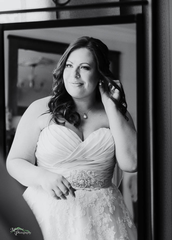 Bride adjusting earring in the mirror