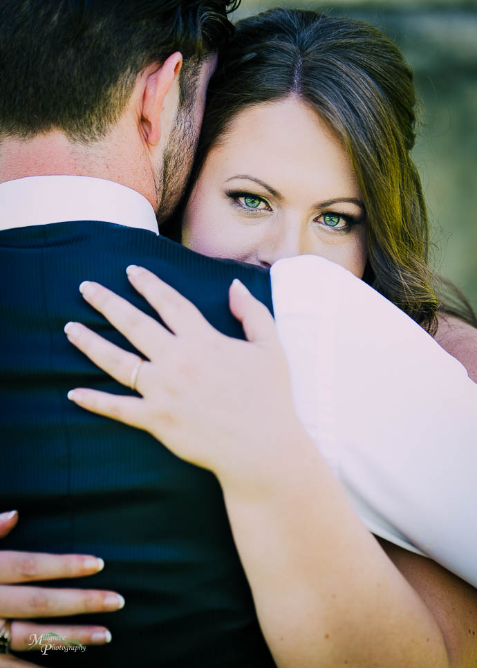 Bride looking over Groom’s shoulder
