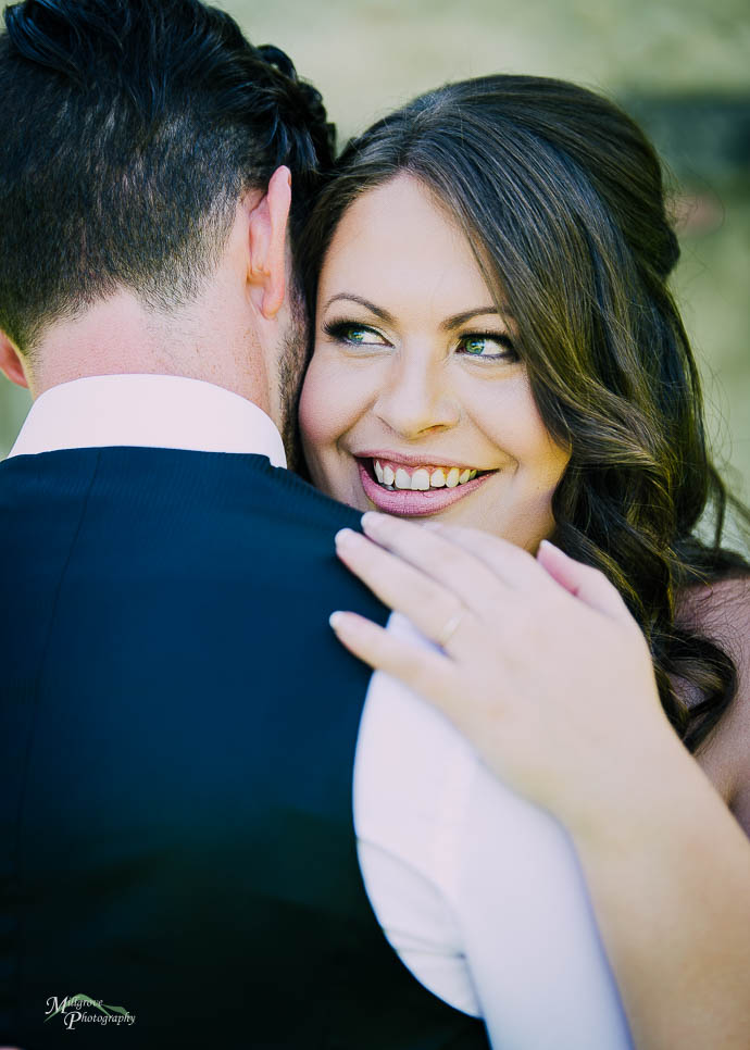 Bride looking over Groom’s shoulder